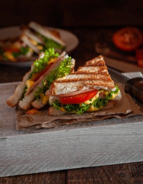 Soslu, jambonlu, sebzeli ve otlu sandviç.