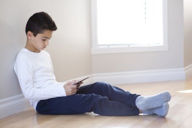 Mobil tablet bilgisayar ile oturan genç çocuk