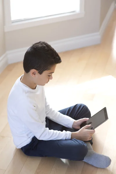 Młody chłopak siedzący z komputer mobilny tablet Obraz Stockowy
