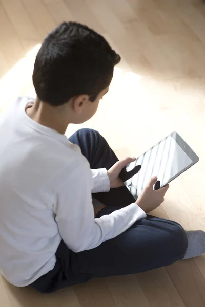 Młody chłopak siedzący z komputer mobilny tablet Zdjęcia Stockowe bez tantiem