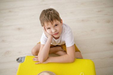 Bavullu çocuk ve maskeli çocuk seyahat için bekliyor..