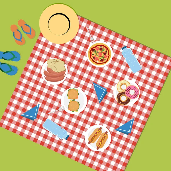Kırmızı bir masa örtüsü üzerinde çayırda piknik. Ürünlerin üst görüntüsü. Abur cubur. Abur cuburla piknik. Fast food. Hızlı karbonhidratlar. - Pizza. Evcil köpek. Burgerler. Hamburgerler. Sosisler. Kadeh kaldıralım.