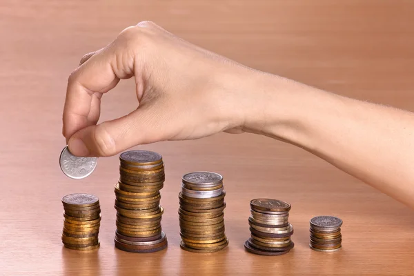 hand stacking coins in piles