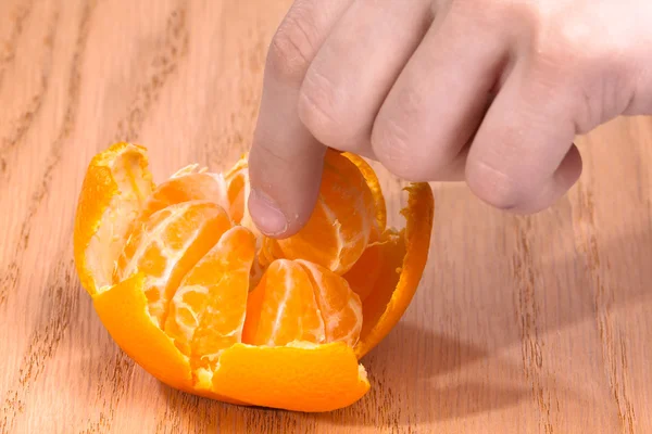 child hand taking slice of tangerine