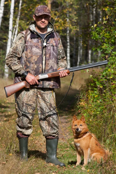 Hunter holding a gun with his dog