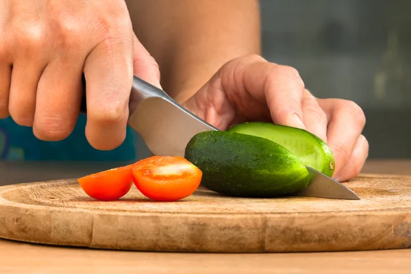 Manos de mujer rebanando pepino en la tabla de cortar — Foto de Stock