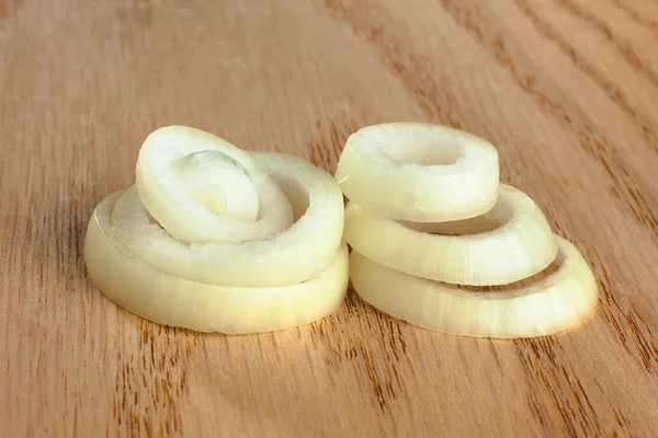 Zwiebelringe auf Holzgrund — Stockfoto