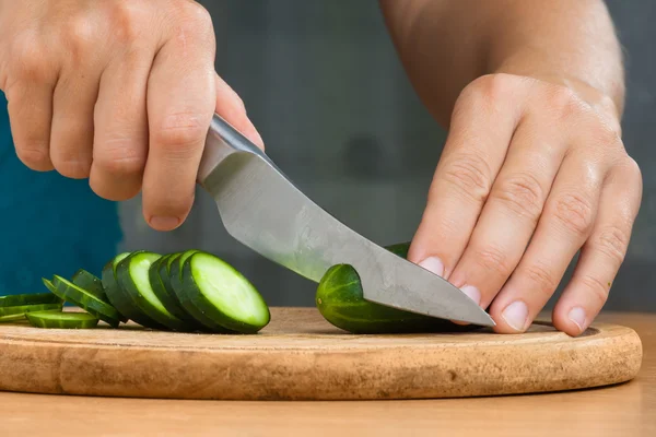 Manos rebanando pepino en la tabla de cortar, primer plano — Foto de Stock