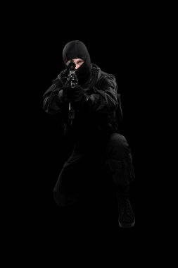 Siyah özel kuvvetler üniformalı silahlı bir erkek. Stüdyoda çekilmiş. Siyah arkaplanda kırpma yolu ile izole edildi (resmi çevir)