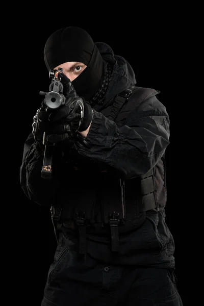 Male in black special forces uniform with pistol. Shot in studio. Isolated with clipping path on black background