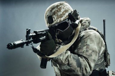 Gri kışlık üniformalı erkek özel kuvvetler askeri. Stüdyoda yeşil arka planda çekilmiş..