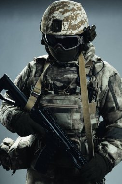 Gri kışlık üniformalı erkek özel kuvvetler askeri. Stüdyoda yeşil arka planda çekilmiş..
