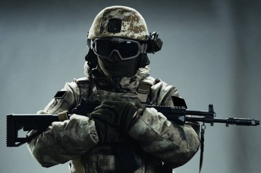 Gri kışlık üniformalı erkek özel kuvvetler askeri. Stüdyoda yeşil arka planda çekilmiş..