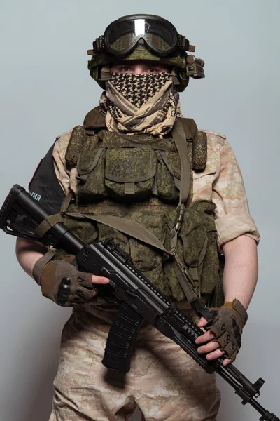 Russian military police soldier in desert uniform. Patch on the shoulder flag of Russia, arms of Russian army and the inscription Military Police in Russian. Shot in studio on a grey background.