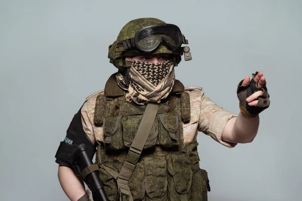 Russian military police soldier in desert uniform. Patch on the shoulder flag of Russia, arms of Russian army and the inscription Military Police in Russian. Shot in studio on a grey background.