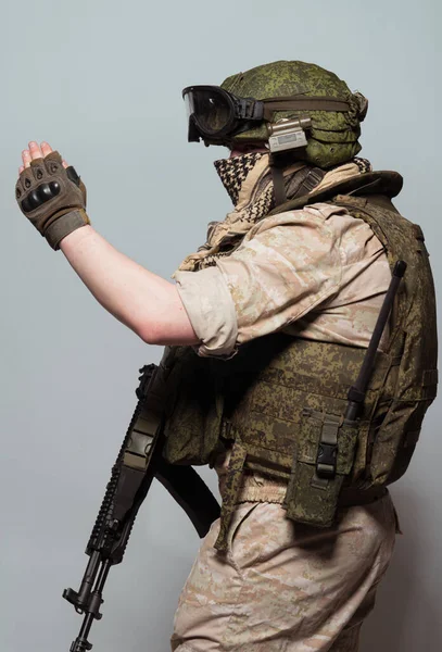 Russian military police soldier in desert uniform. Patch on the shoulder flag of Russia, arms of Russian army and the inscription Military Police in Russian. Shot in studio on a grey background.