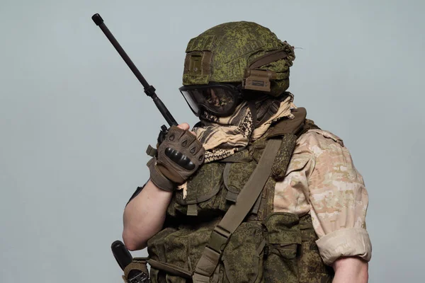 Russian military police soldier in desert uniform. Patch on the shoulder flag of Russia, arms of Russian army and the inscription Military Police in Russian. Shot in studio on a grey background.