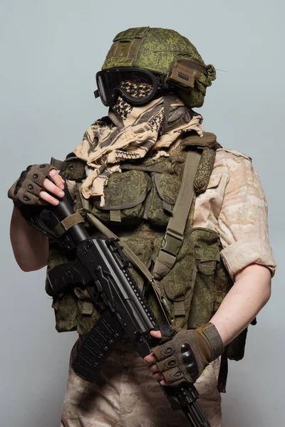 Russian military police soldier in desert uniform. Patch on the shoulder flag of Russia, arms of Russian army and the inscription Military Police in Russian. Shot in studio on a grey background.