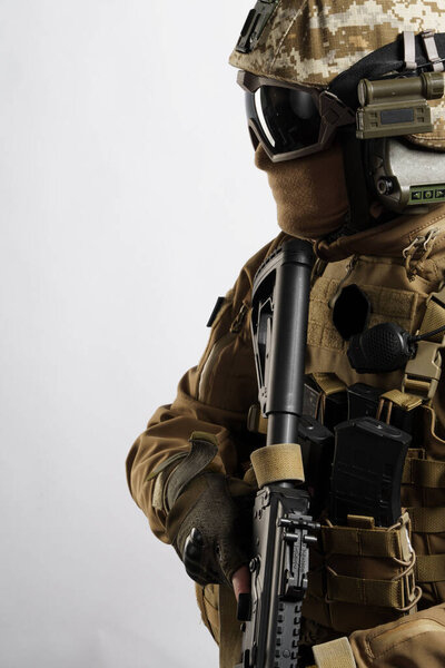 Мужчина в тактической экипировке и форме (коричневого цвета койота). Съемки в студии на белом фоне