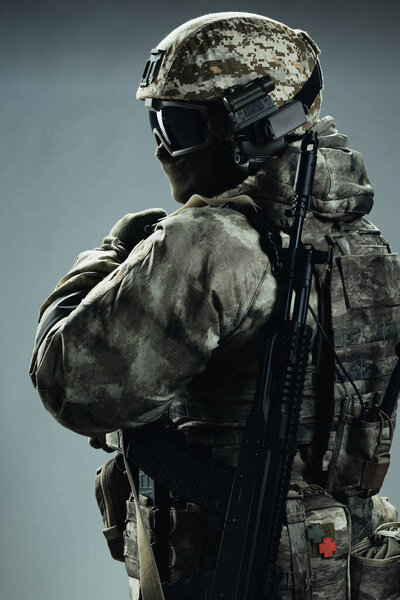 Солдат спецназа в серой зимней форме. Съемки в студии на зеленом фоне.