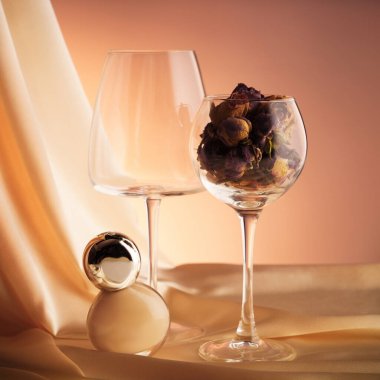 İki bardak zıt güller, bir kavanoz fondöten ya da tonal krem, arka planda altın kumaş. Stüdyoda çekilmiştir (Güzellik konsepti posteri, ters görüntü)