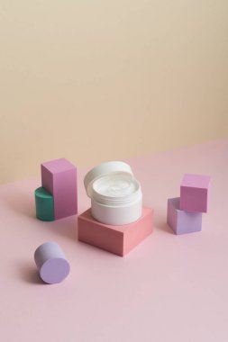 Bej ve pembe arka planda beyaz kozmetik krem kavanozu. (Güzellik konsepti posteri, ters görüntü)