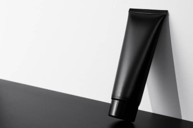 Beyaz arka planda krem siyah tüp. Kozmetik cilt bakımı ürünü. Beyaz markasız losyon, balsam, el kremi, diş macunu modeli..