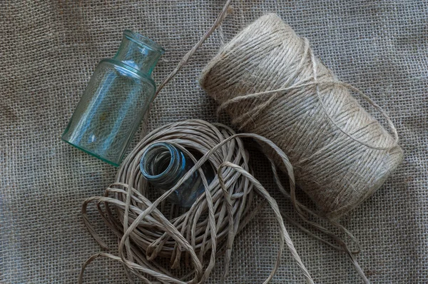 Bottles and a coil of rope — Stock Photo, Image