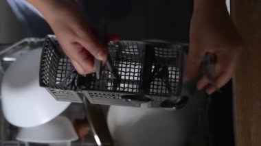 Üst taraf, ellerinde çatal bıçak, kaşık ve bıçakları kaldıran bir çatal bıçak kabıyla el ele tutuşuyor. Üst mutfak rutini evde sofra takımlarının düzenli düzenlendiğini gösteriyor.