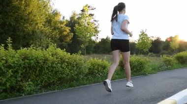 Genç bir kadın ağır çekimde gün batımına doğru koşuyor. Altın parıltıyla dolu arka plan izleme çekimi ilham verici ve sinematik şehir atmosferi yaratır. Özgürlük, motivasyon ve aktif yaşam tarzı kavramları için ideal.