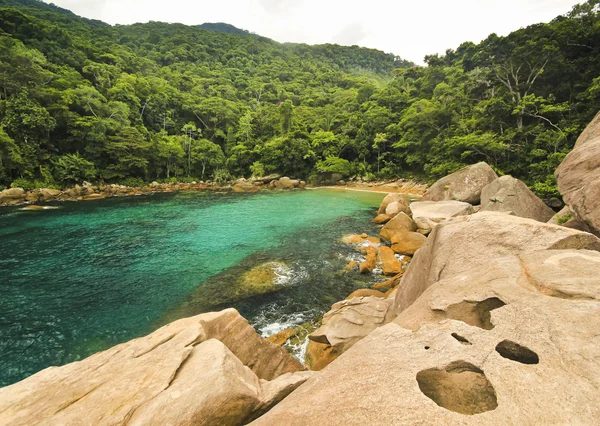 Praia tropical com água verde, pedras na costa e fundo — Fotografia de Stock