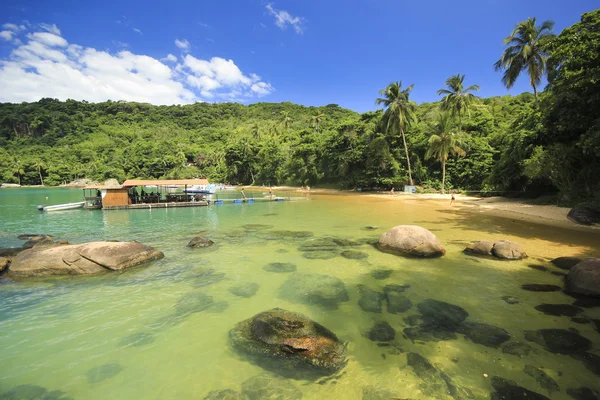 Belle plage tropicale avec de l'eau verte et restaurant dedans — Photo