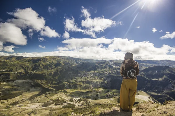 Fata stând pe un deal uitându-se la munți împotriva soarelui — Fotografie, imagine de stoc