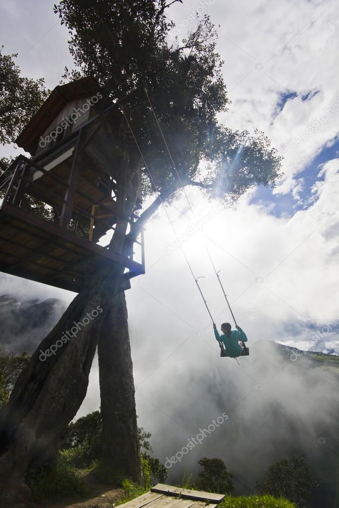 girl swinging in ecuador mountains  against sun