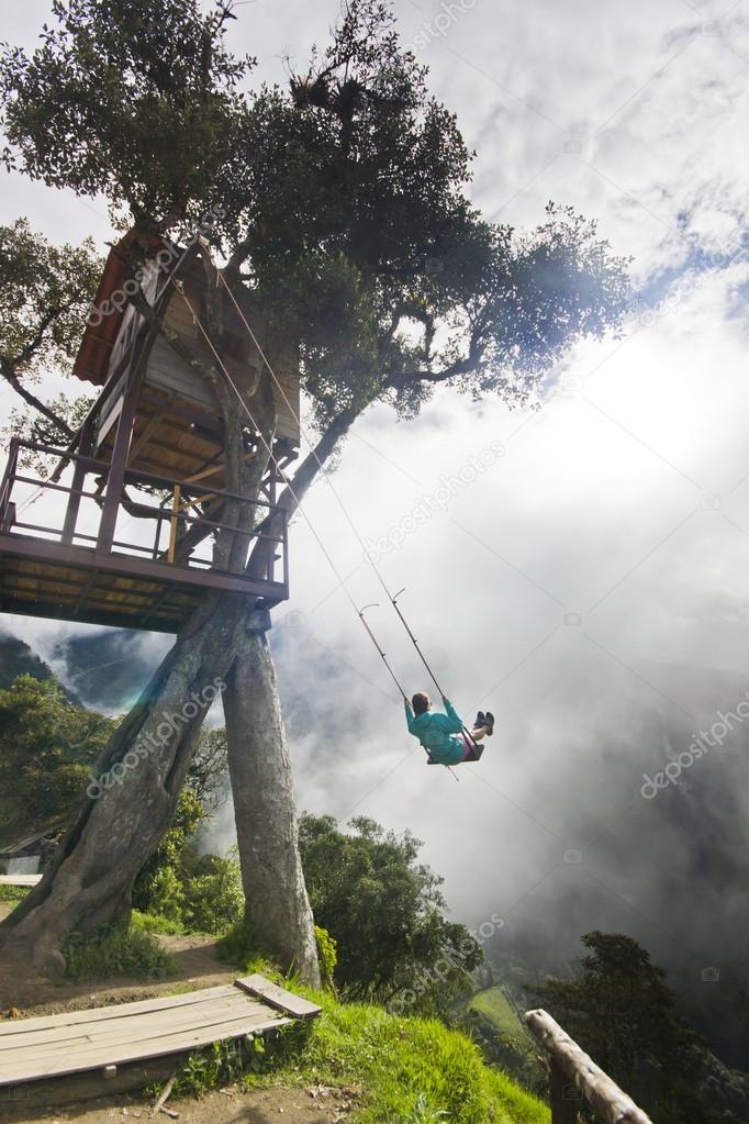 girl swinging in ecuador mountains  against sun