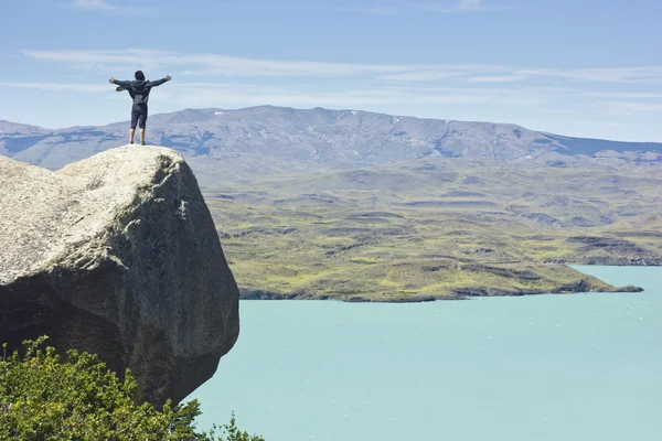 Man på klippan i bergen på ovanför sjön — Stockfoto