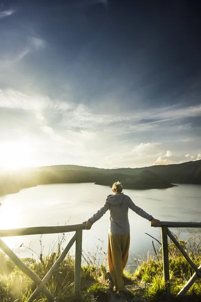 Girl standing on a edge of crater with lake inside — Stock Photo, Image