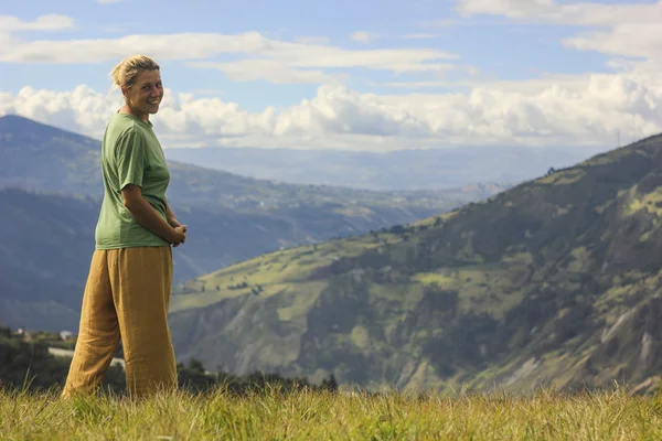 sarışın kız ayakta ve yarım dönüş seyir için kamera gülümseyen