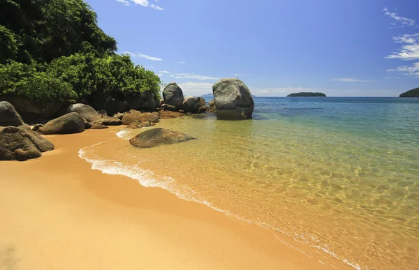 Pięknej tropikalnej plaży zielone wody i kamieni na brzegu — Zdjęcie stockowe