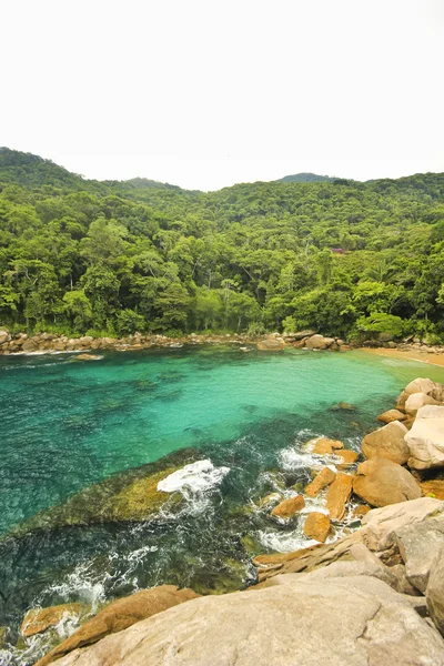 Praia tropical com água verde, pedras na costa e fundo — Fotografia de Stock