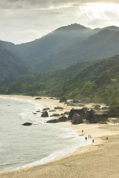 Beautiful tropical beach with big stones on shore and mountains — Stock Photo, Image