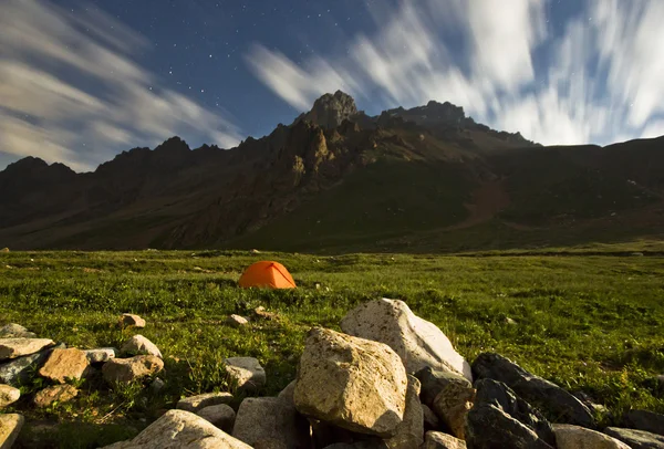 Orange tent on green hills of high mountains in moonlight — Stock Photo, Image