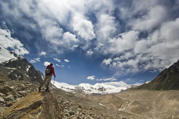 Чоловік стоїть на скелі в горах з полюсами — стокове фото