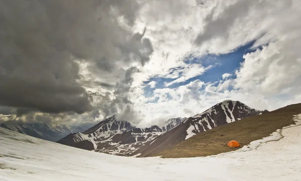 Oranžový stan na zasněžený průsmyk v horách na denní světlo — Stock fotografie