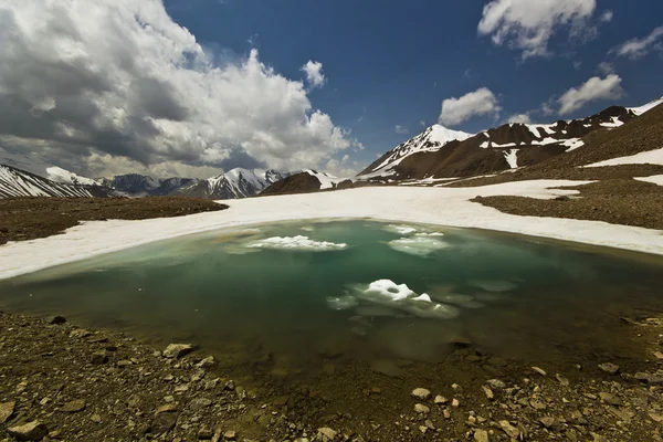 Lago azul de montaña rodeado de altos picos a la luz del día — Foto de Stock