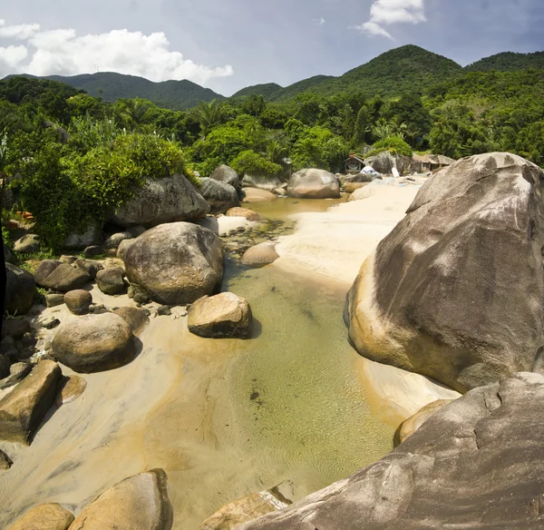 Bela costa tropical com rio e pedras — Fotografia de Stock