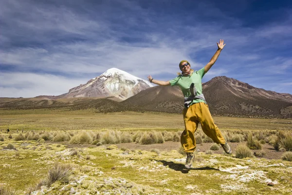 Chica saltando y sonriendo cerca del volcán Sajama en Bolivia — Foto de Stock