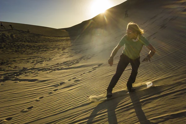 gün batımında çölde sandboard adam