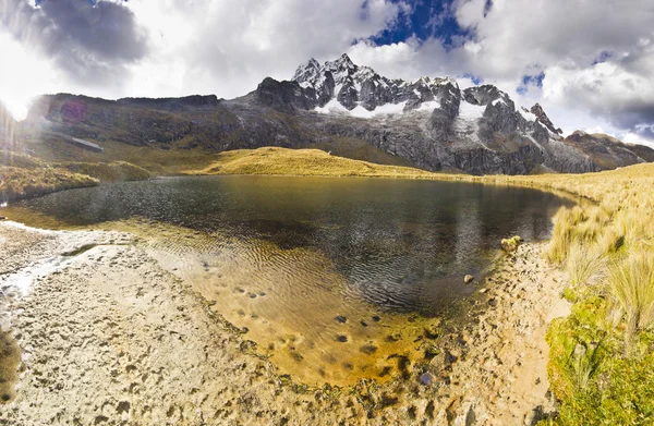 Lago buio in piedi di montagna innevata al tramonto — Foto Stock