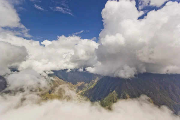 Огромные белые облака над зелеными горами — стоковое фото